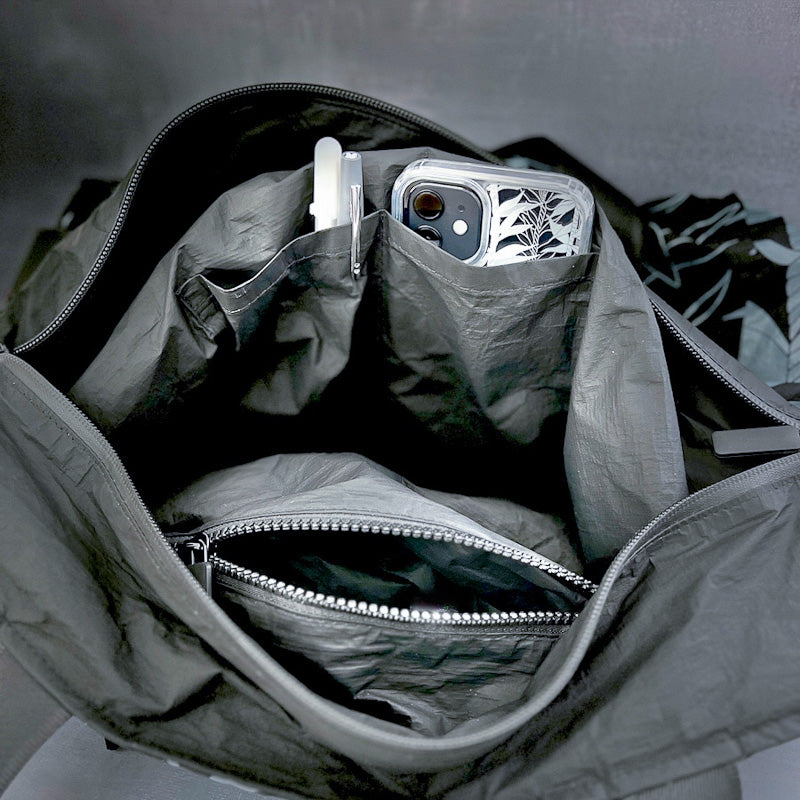 Close_up_of_Tyvek_tote_showing_multiple_inside_organization_pockets_holding_phone_and_pens