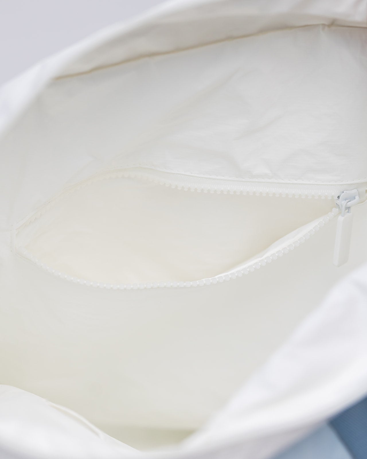 Close up of inside of puakenikeni tyvek tote showing inside zippered pocket.