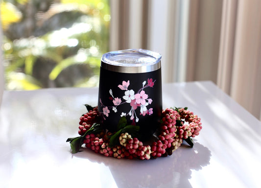 Black 12 oz insulated wine tumbler with pink and white sakura blooms design.
