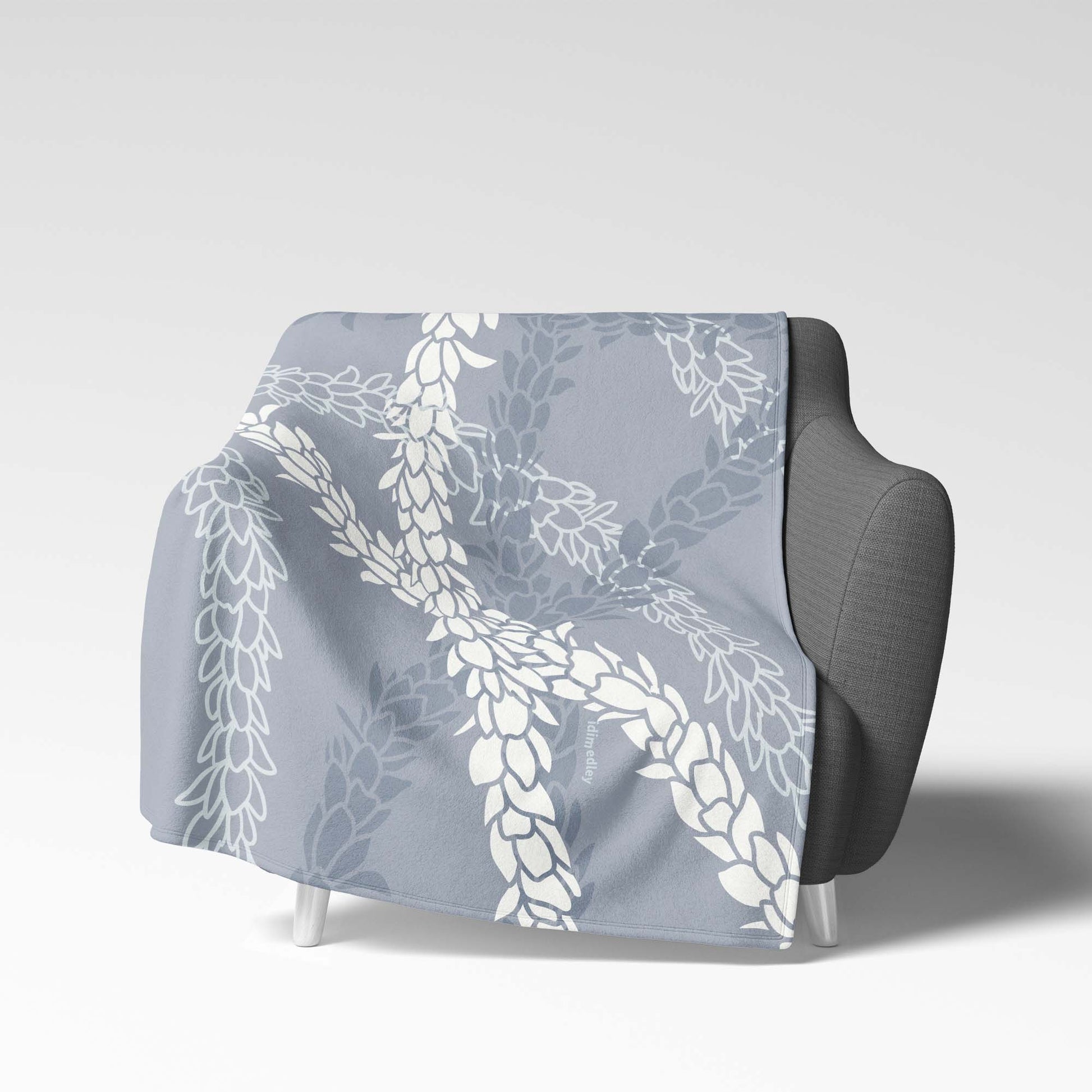 Soft velveteen blanket with a design displaying multiple Pikake flower lei strands in shades of gray and white silhouettes and white line art on a light blue background.