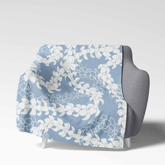 Soft velveteen blanket with a design displaying multiple Puakenikeni flower lei strands in white silhouettes and line art on a light blue background.