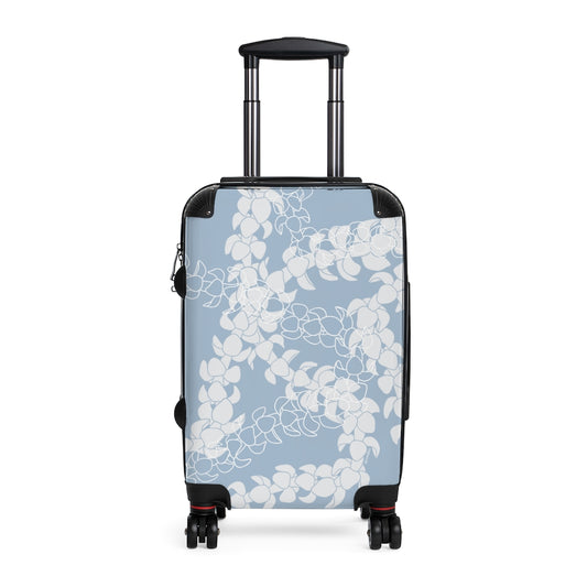Rolling, hard shell carryon luggage with light blue and white Puakenikeni flower lei design. 
