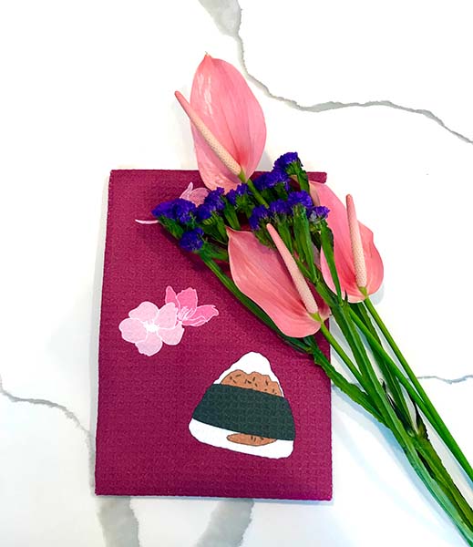 ebi ten musubi and cherry blossom design magenta dishtowel on kitchen counter with pink anthurium flowers