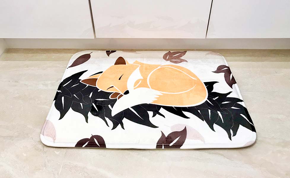 sleeping fox on maile leaf lei in front of white cabinets of bathroom floor